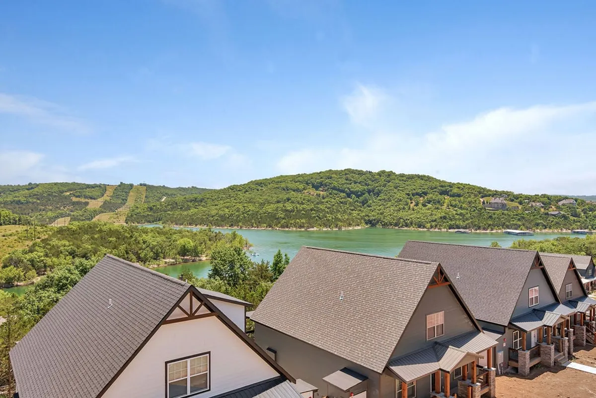 A panoramic view of Table Rock Lake with rolling hills and lakeside homes, evoking tranquility and natural beauty. The vantage point invites exploration and scenic walks, ideal for family strolls and photo opportunities.