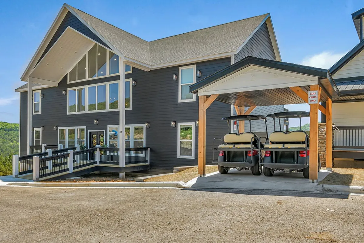 A striking exterior shot showing the modern architecture of Governors Getaway, large windows, and golf carts parked in front. The scene is set at sunset, with warm lighting hinting at lively gatherings and adventures. The setting effortlessly connects the home to the outdoor lifestyle, with clear cues for golf and relaxation.