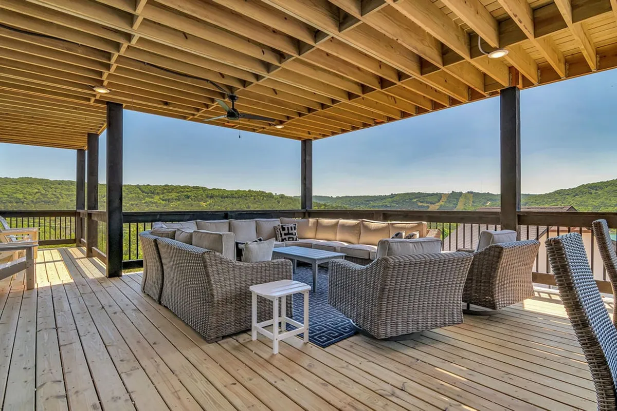 A wide deck with ample seating and a stunning mountain view, designed for relaxation and large social gatherings. The open-air setting is perfect for stargazing or enjoying group activities in the fresh air.