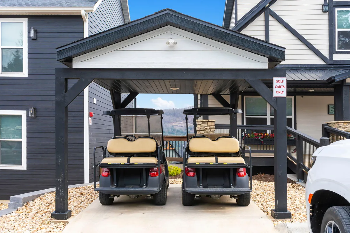 An image of the resort’s exterior featuring golf carts parked under a carport, surrounded by landscaped grounds and open sky. The scene hints at easy access to recreational activities and movement around the resort.